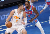 Orlando Magic center Nikola Vucevic (9) drives against Brooklyn Nets forward Kevin Durant (7) during the first half of an NBA basketball game, Saturday, Jan. 16, 2021, in New York. (AP Photo/Mary Altaffer)