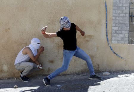 Palestinian youths throw stones towards Israeli police during clashes in the East Jerusalem neighbourhood of A-tur, after a Palestinian youth was killed by Israeli security forces April 25, 2015. REUTERS/Ammar Awad