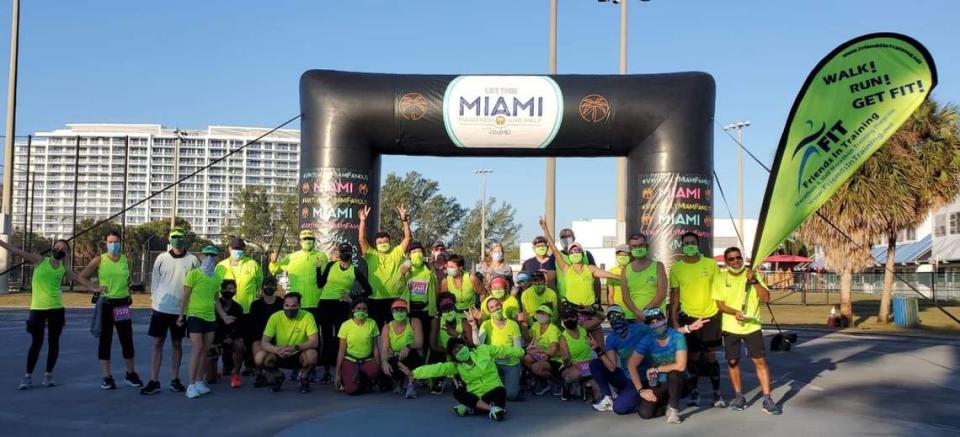 Marathoner Marcela Todd sits in front of her Friends in Training group in January 2021 after they ran the half marathon distance of the #VirtuallyMiamiFamous race at George English Park in Fort Lauderdale.