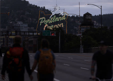 People walk on a street the evening before a scheduled protest in Portland, Oregon, U.S. June 3, 2017. REUTERS/Jim Urquhart