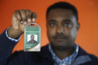 In this photo taken Sept. 24, 2019, Yonas Yeshanew, who resigned as Ethiopian Airline's chief engineer this summer and is seeking asylum in the U.S., poses with his company's identification card in the Seattle area. Yeshanew says in a whistleblower complaint filed with regulators that the carrier went into the maintenance records on a Boeing 737 Max jet a day after it crashed this year, a breach he contends was part of a pattern of corruption that included fabricating documents, signing off on shoddy repairs and even beating those who got out of line. (AP Photo/Elaine Thompson)