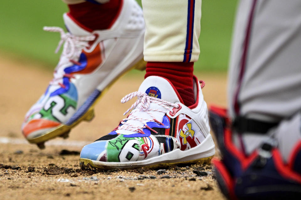 Philadelphia Phillies' Bryce Harper steps into the batters box during the first inning of a baseball game against the Atlanta Braves, Saturday, March 30, 2024, in Philadelphia. Former Philadelphia Eagle Jason Kelce autographed Harper's shoe after throwing out the first pitch. (AP Photo/Derik Hamilton)