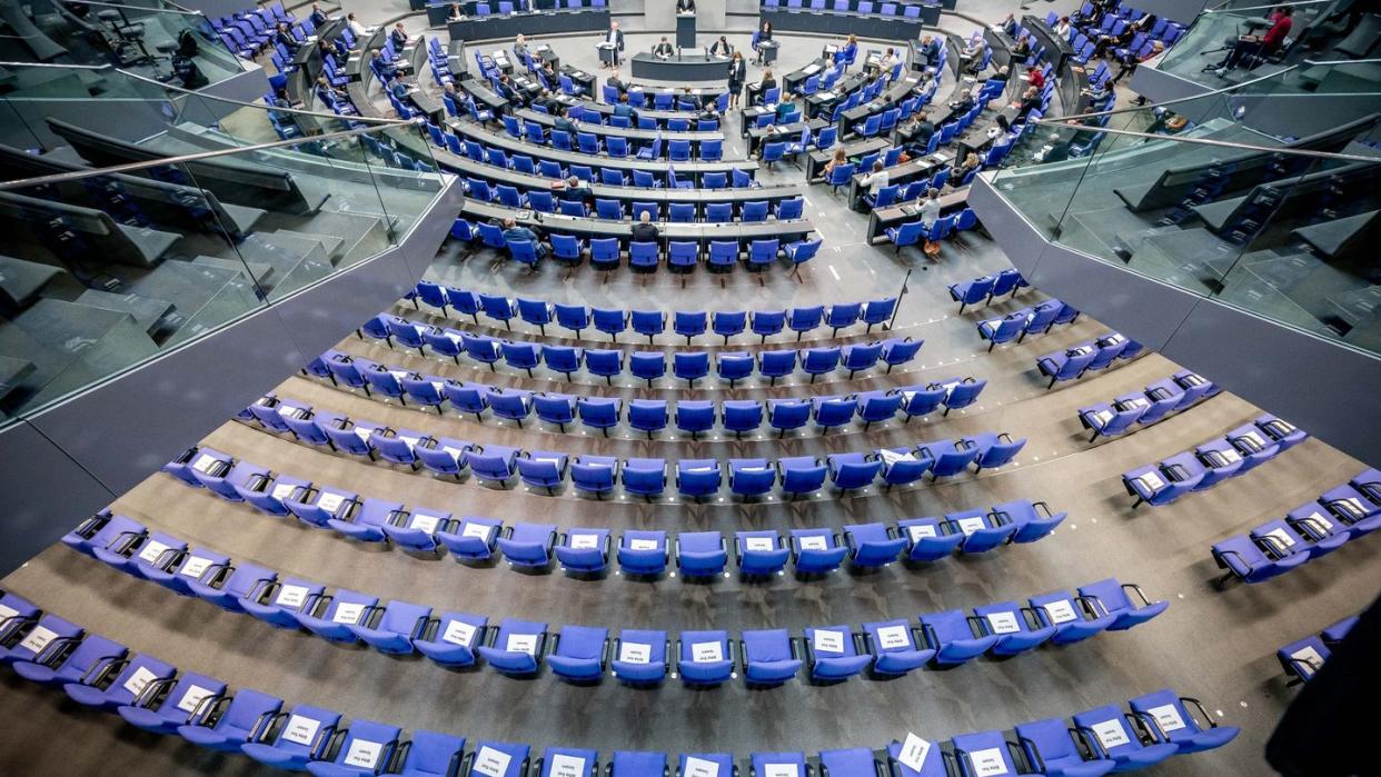 Stühle für die Abgeordneten, aufgenommen im Plenum in Deutschen Bundestag. Auf einigen der Stühle liegen Zettel mit der Aufschrift "Bitte frei lassen".
