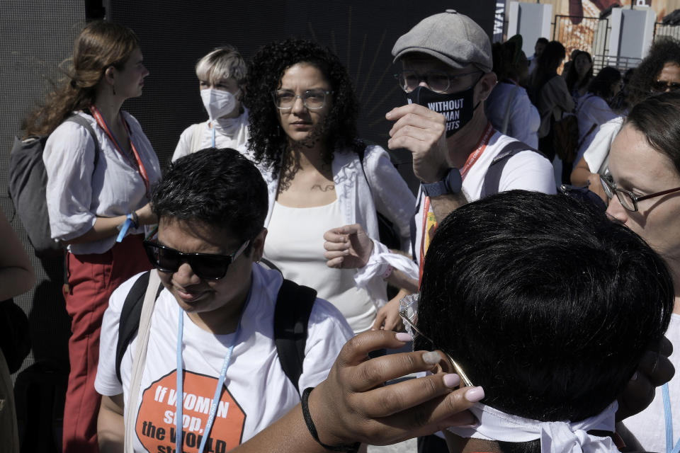 Sanaa Seif, center left, sister of Egypt's jailed leading pro-democracy activist Alaa Abdel-Fattah, who is on a hunger and water strike, walks past a demonstration in support of political prisoners as well as human rights defenders and environmental activists, at the COP27 U.N. Climate Summit, Thursday, Nov. 10, 2022, in Sharm el-Sheikh, Egypt. (AP Photo/Nariman El-Mofty)