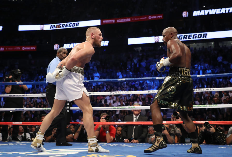 <p>(L-R) Floyd Mayweather Jr. throws a punch at Conor McGregor during their super welterweight boxing match on August 26, 2017 at T-Mobile Arena in Las Vegas, Nevada. </p>