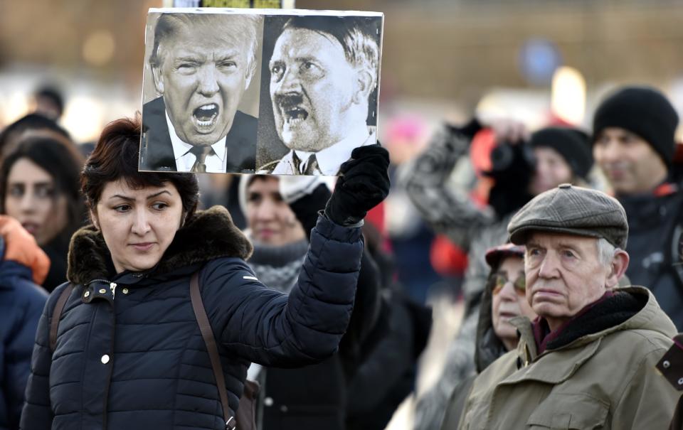 A participant of a Women's March in Helsinki holds up a poster depicting US President Donald Trump and German dictator Adolf Hitler on January 21, 2017, one day after the US president's inauguration.&nbsp;