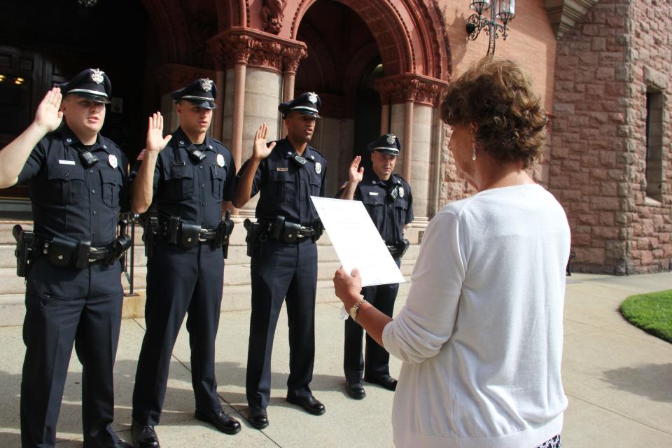 Fairhaven Town Clerk Eileen Lowney swears in new police officers, from left, Jonathan Alves, Matthew Sobral, Jerome Penha Jr. and Scott Coelho in August 2015.