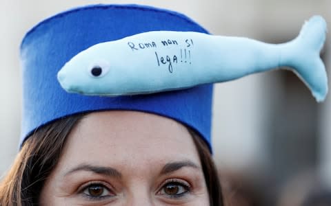 A protester wears a hat with a sardine puppet where it reads ''Rome does not bind'' during a demonstration held by "the sardines", a grassroots movement against far-right League leader Matteo Salvini - Credit: Reuters