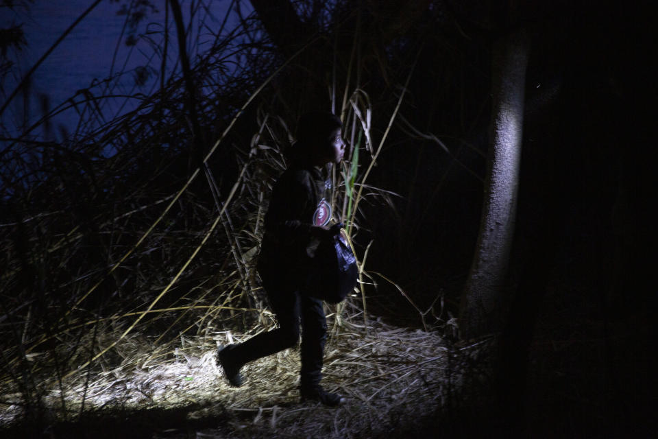 A young child walks alone through the brush after being smuggled across the Rio Grande river in Roma, Texas, Wednesday, March 24, 2021. (AP Photo/Dario Lopez-Mills)