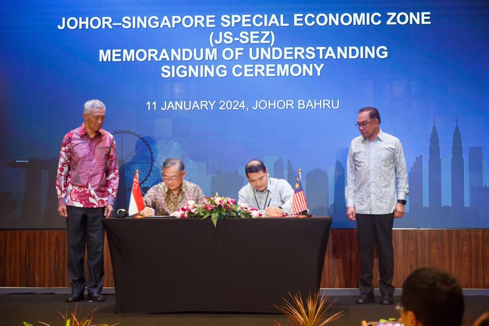 Lee Hsien Loong, left, and Anwar Ibrahim, right, witness the signing of the ageement in Johor Bahru on Jan. 11.