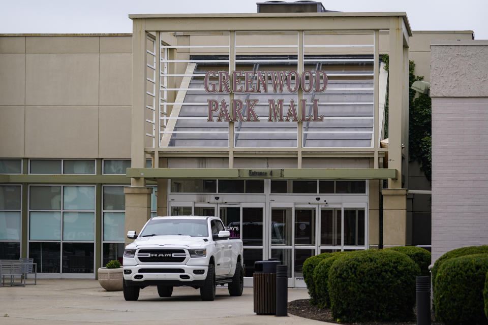 A truck blocks the entrance to the closed Greenwood Park Mall in Greenwood, Ind., Monday, July 18, 2022. The mall was closed Monday after police say three people were fatally shot and two were injured, including a 12-year-old girl, after a man with a rifle opened fire in a food court and an armed civilian shot and killed him. (AP Photo/Michael Conroy)