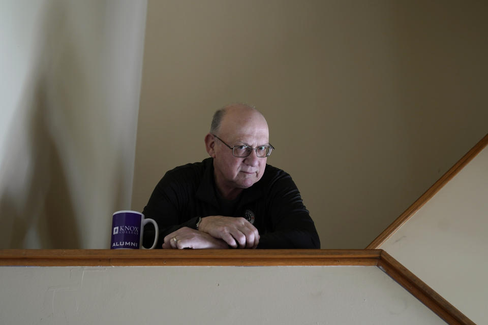 Roger Strukhoff 67, poses for a portrait Thursday, Jan. 20, 2022, in his DeKalb, Ill., home. Strukhoff was being treated for intestinal bleeding at a hospital outside Chicago this month when he suffered a mild heart attack. Normally, the medical staff would have sent Strukhoff to the intensive care unit, but, overrun with COVID-19 patients, the staff instead had to wheel a heart monitor into his room and quickly administer nitroglycerin and morphine. (AP Photo/Charles Rex Arbogast)