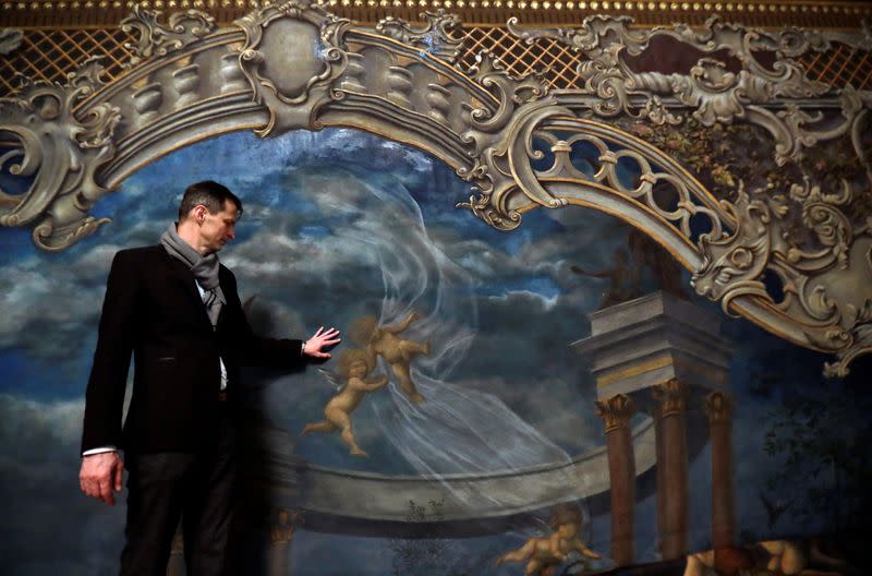 Czech painter Martin Cerny stands in front of a newly installed curtain during a renovation of Prague's State Opera building