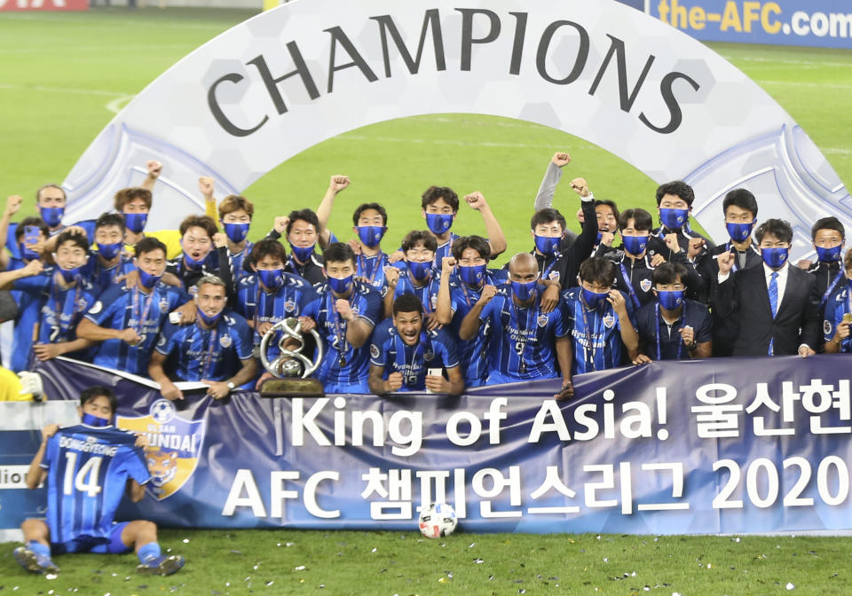 Ulsan Hyundai's players pose with a trophy after the AFC Champions League final match against Persepolis in Al Wakrah, Qatar, Saturday, Dec. 19, 2020. (AP Photo/Hussein Sayed)