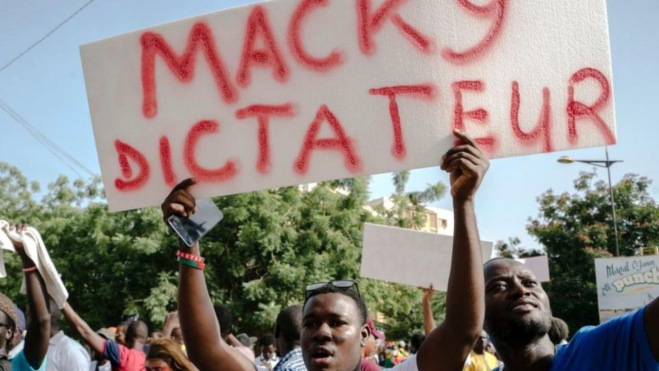A demonstrator holds a placard reading "Macky dictator" during a rally to demand the release of detained Senegalese opposition leader Ousmane Sonko.