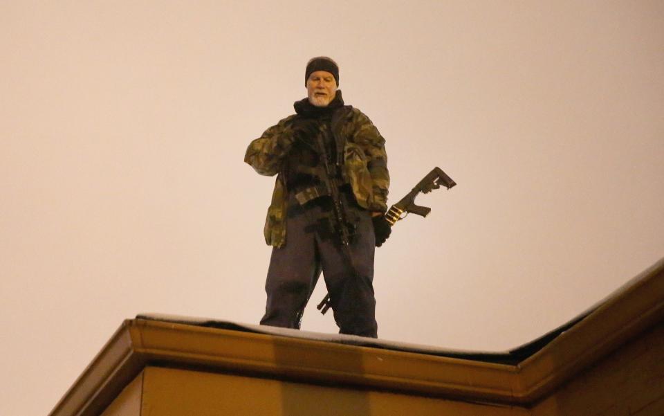 John Karriman. a volunteer from Oath Keepers, stands guard on the rooftop of a business in Ferguson, Mo., Nov. 26, 2014. (Scott Olson/Getty Images)