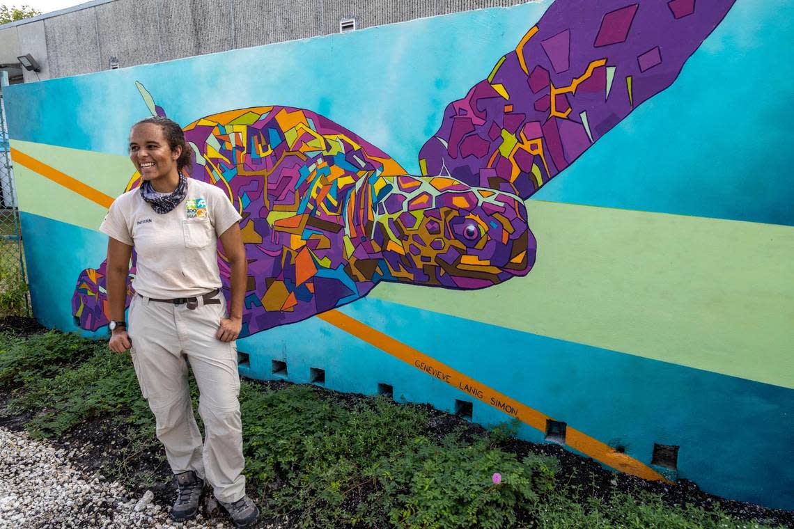 Genevieve Simon stands in front of a mural she painted on one of the walls by the entrance of the turtle hospital on July 6, 2022.