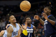 Memphis Grizzlies guard Ja Morant (12), Minnesota Timberwolves center Naz Reid (11) and guard Anthony Edwards (1) watch a loose ball in the first quarter of an NBA basketball game Wednesday, Nov. 30, 2022, in Minneapolis. (AP Photo/Andy Clayton-King)