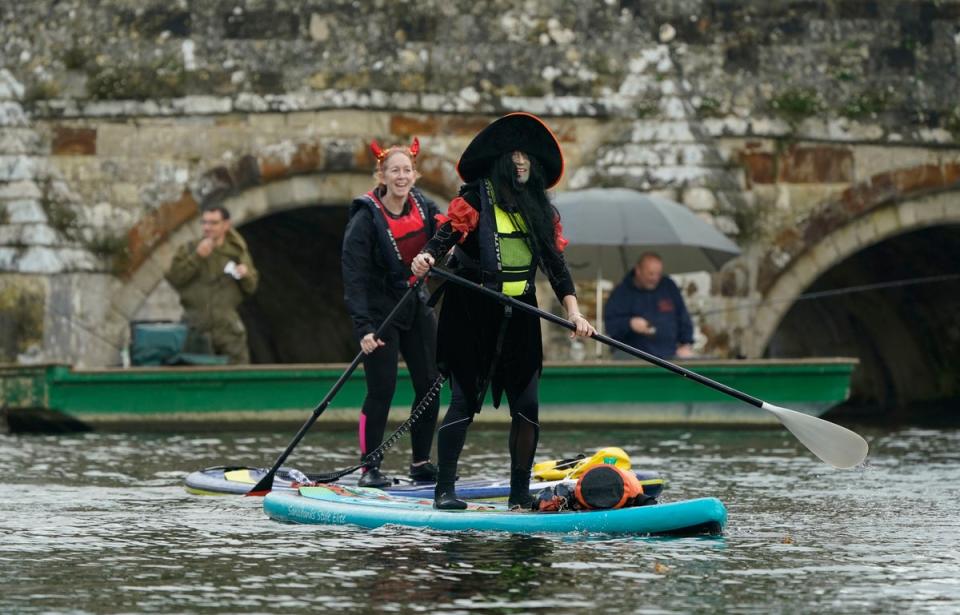 30 October 2022: People dressed in Halloween costumes paddle board along the river Avon in Christchurch, Dorset (PA)