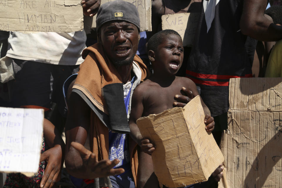 African migrants protest on the Libyan border with Tunisia on Thursday, Aug. 4, 2023. The Tunisian security forces reportedly expelled hundreds of migrants over the border into Libya, where they have been stranded in scorching summer temperatures without water and food since June. (AP Photo/Yousef Murad)