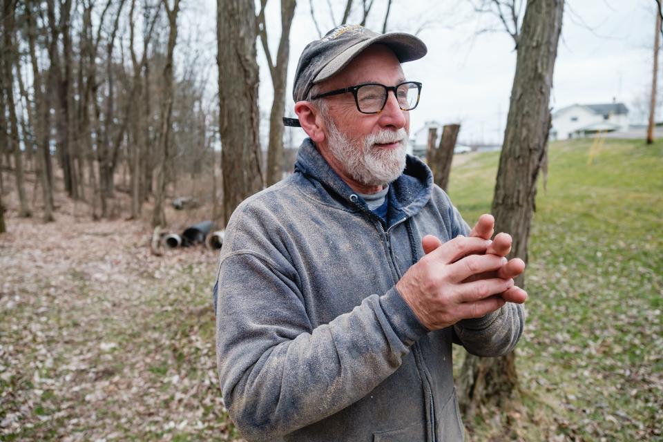 Dan Kidd talks about the process of envisioning chainsaw carvings in tree stumps while taking a break from carving an eagle on private property in Sherrodsville.