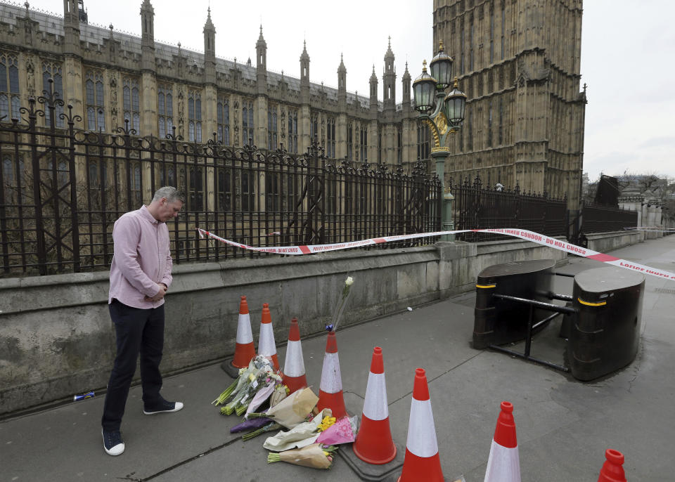 Un hombre observa el homenaje floral a las víctimas del ataque terrorista en las inmediaciones del Parlamento, el jueves 23 de marzo del 2017, un día después de que un hombre armado con un cuchillo arremetiera su auto contra peatones y luego matara a puñaladas a un policía en las inmediaciones del Parlamento. Policías luego mataron a tiros al hombre. (AP Foto/Tim Ireland)