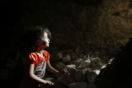 A girl is seen at a makeshift shelter in an underground cave in Idlib, Syria September 3, 2018. Picture taken September 3, 2018. REUTERS/Khalil Ashawi