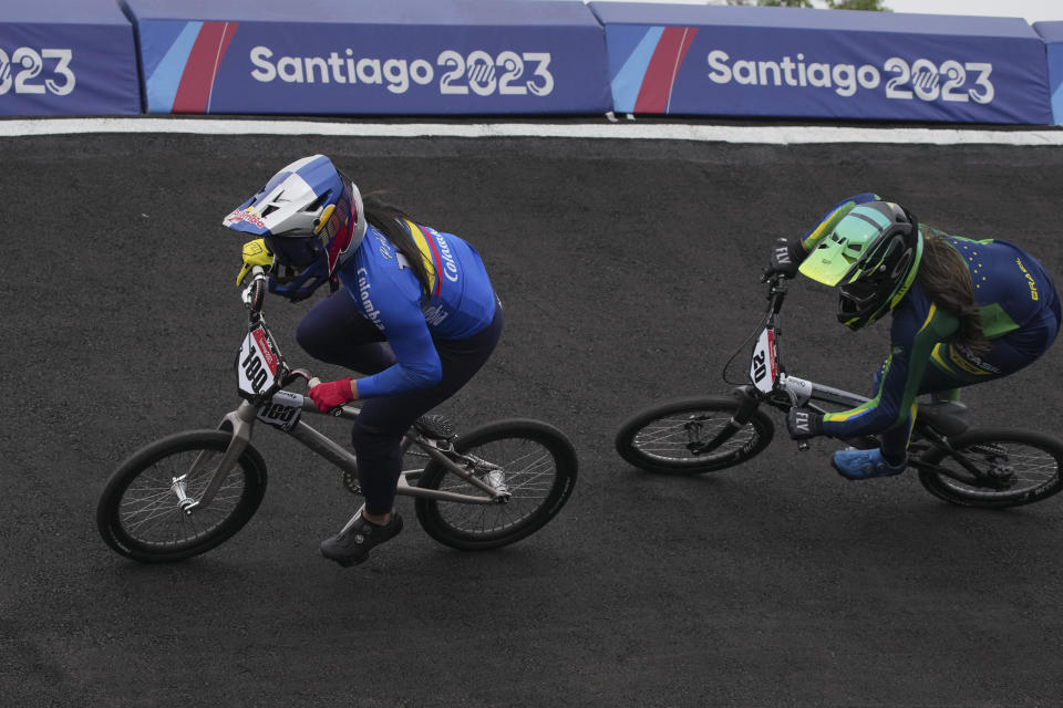 La colombiana Mariana Pajón (izquierda) y la brasileña Paola Reis Santos compiten en el BMX femenino de los Juegos Panamericanos en Santiago, Chile, el domingo, 22 de octubre de 2023. (AP Foto/Dolores Ochoa)