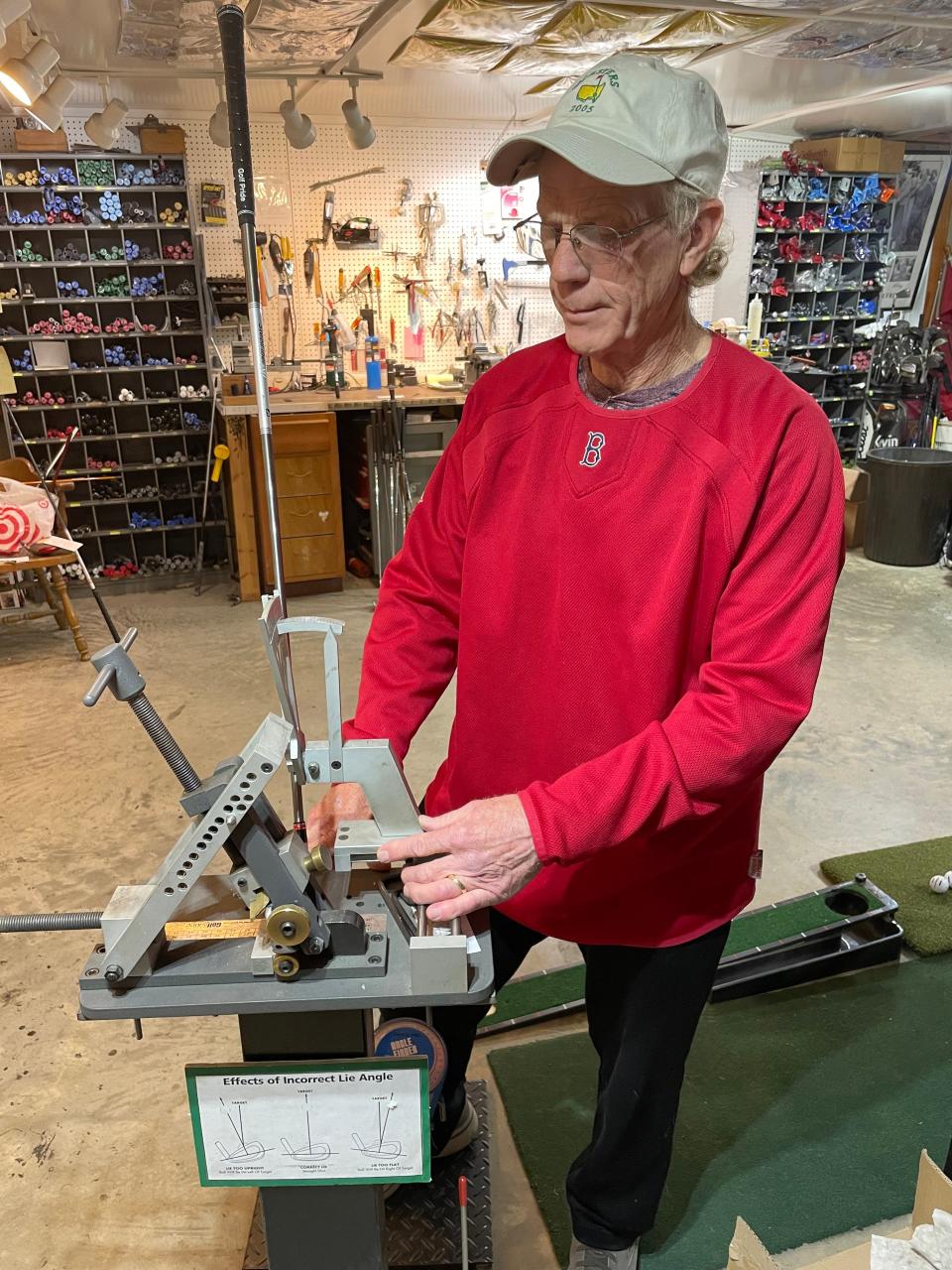 Don Sharron checks the loft and lie of a 4-iron in his Grip & Rip It Golf work shop in the basement of his home in Boylston.