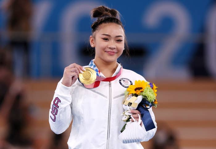 Suni holds up her gold medal at the Olympics