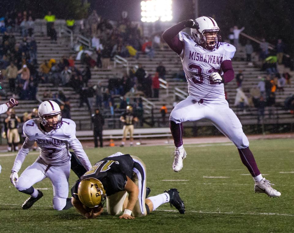 10/13/2018: Tribune Photo/MICHAEL CATERINAMishawaka’s Derrick Dawson celebrates after Carl Fisher III takes down Penn quarterback Ron Powlus to seal the overtime victory for the CavemenFriday night at Penn.Mishawaka's Derrick Dawson celebrates after Carl Fisher III takes down Penn's Ronald Powlus to seal the overtime victory for the Cavemen during the Mishawaka at Penn High School football game Friday, Oct. 12, 2018.