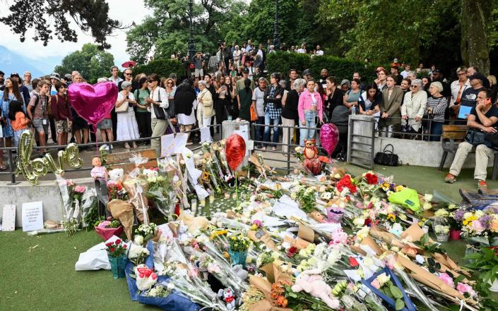 People gather to lay flowers for the victims of the stabbing attack in Annecy, France - OLIVIER CHASSIGNOLE/AFP