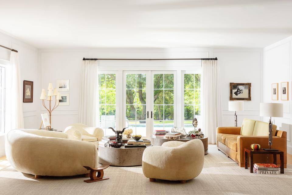 A Royère Polar Bear sofa and armchairs mingle with a custom suede–and–hide hair sofa. Lamps by John De La Rosa on lacquered side tables; Royère floor lamp. artwork (right) by Warhol.