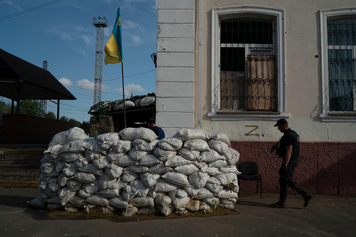 A member of the State Emergency Service of Ukraine enters in the basement of the train station fortified with sand bags that, according to Ukrainian authorities, was used as an interrogation room during the Russian occupation in the retaken village of Kozacha Lopan, Ukraine, Sunday, Sept. 18, 2022.