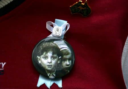 A relative wears a pin displaying a photograph of children who he said had been sexually abused by the Catholic Church as he stands outside the venue for Australia's Royal Commission into Institutional Response to Child Sexual Abuse in Sydney, Australia, February 29, 2016. REUTERS/David Gray