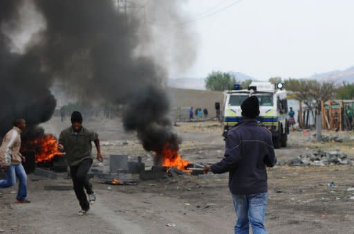 Striking miners flee South African police in Marikana. South African police fired rubber bullets at protesters and raided worker hostels at platinum giant Lonmin to seize weapons in a crackdown on unrest in the key mining industry Saturday