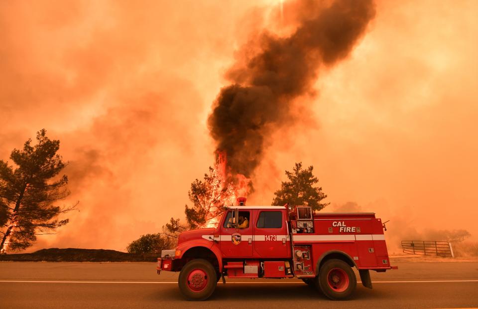 <p>Firefighters work to control a fire as flames from the County Fire jump across Highway 20 near Clearlake Oaks, Calif. on July 1, 2018. (Photo: Josh Edelson/AFP/Getty Images) </p>