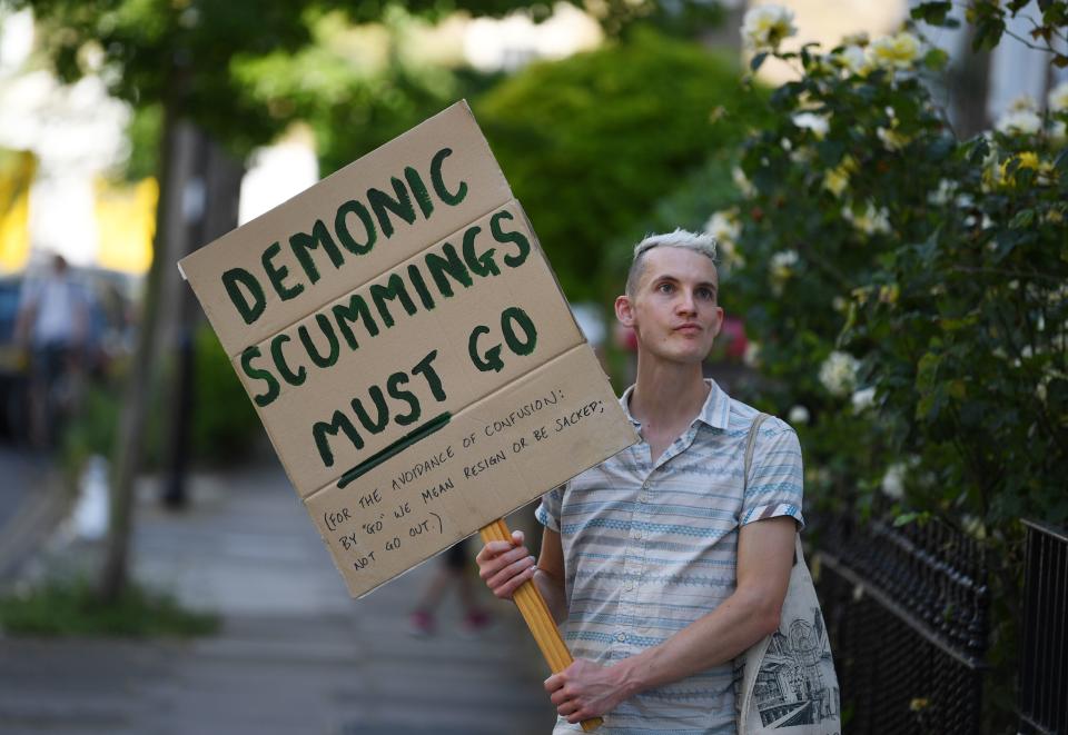 A demonstrator displays a homemade placard calling for 10 Downing Street special advisor Dominic Cummings to resign or be fired outside his home in London on May 25, 2020 following allegations he broke coronavirus lockdown rules by travelling across the country in March. - British Prime Minister Boris Johnson on May 24 defied pressure from within his own party and backed top aide Dominic Cummings over allegations he breached coronavirus lockdown rules. (Photo by DANIEL LEAL-OLIVAS / AFP) (Photo by DANIEL LEAL-OLIVAS/AFP via Getty Images)