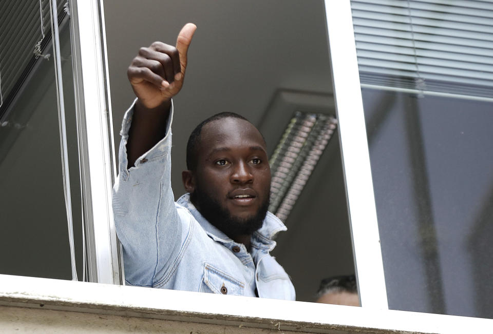 El delantero belga Romelu Lukaku saluda a hinchas del Inter de  Milán desde una ventana en la sede del Comité Olímpico de Italia en Milán el jueves, 8 de agosto del 2019. Lukaku está al borde de completar un traspaso de Manchester United al Inter.  (AP Foto/Luca Bruno)