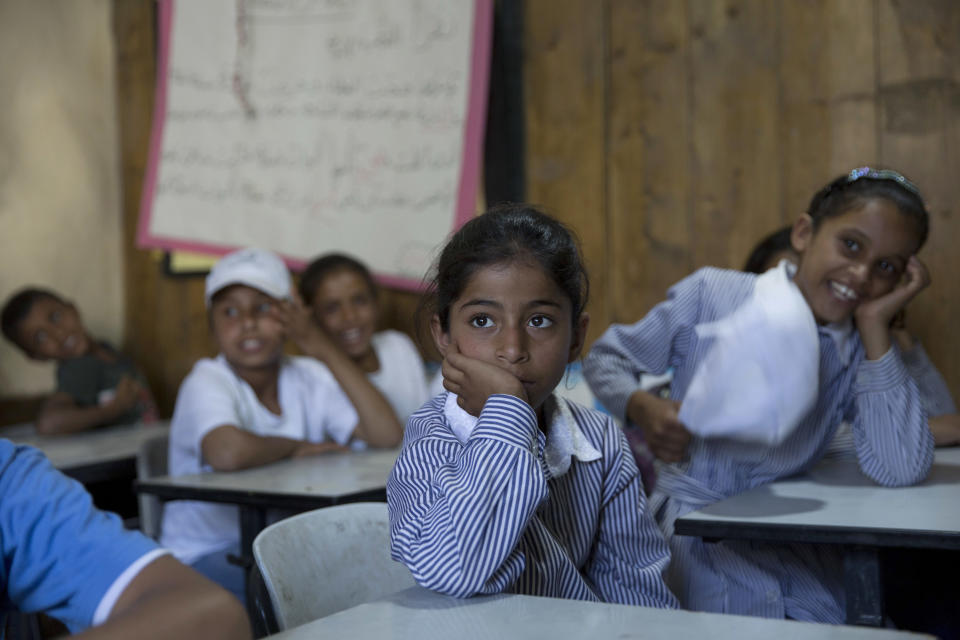 FILE - In this July 16, 2018 file photo, Palestinians attend school in the West Bank Bedouin community of Khan al-Ahmar. Qatar's Foreign Ministry said Tuesday, May 7, 2019, that it will send $480 million to Palestinians in the West Bank and the Gaza Strip after a cease-fire deal ended the deadliest fighting between Israel and Palestinian factions since a 2014 war. A statement from Qatar said $300 million would support health and education programs of the Palestinian Authority, while $180 million would go toward "urgent humanitarian relief" in United Nations programs and toward electricity. (AP Photo/Nasser Nasser, File)