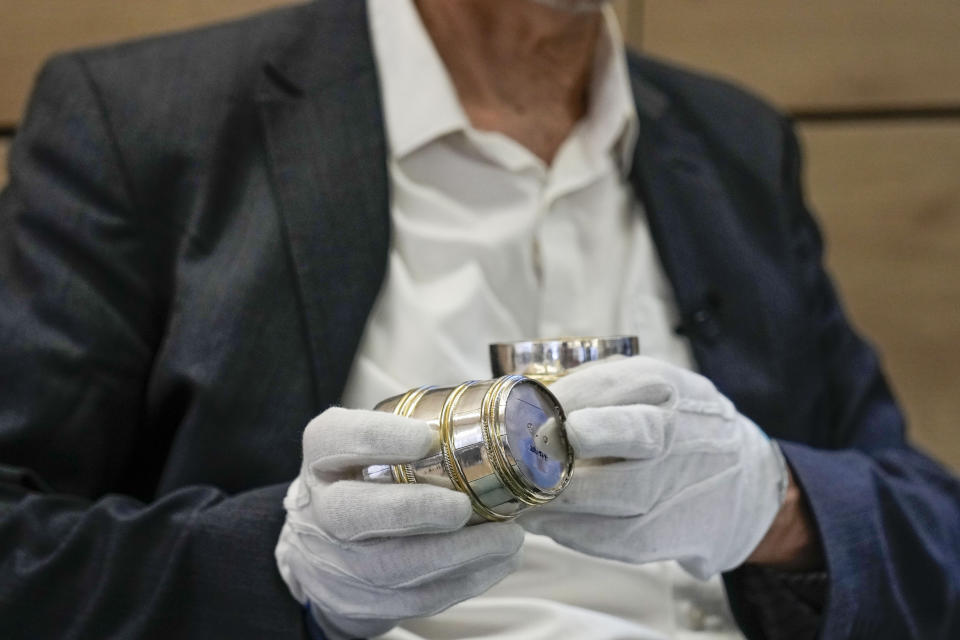 Art historian Matthias Weniger, from the Bavarian National Museum, holds silver glass by Jews, in Tel Aviv, Israel, Thursday, June 1, 2023. (AP Photo/Ariel Schalit)