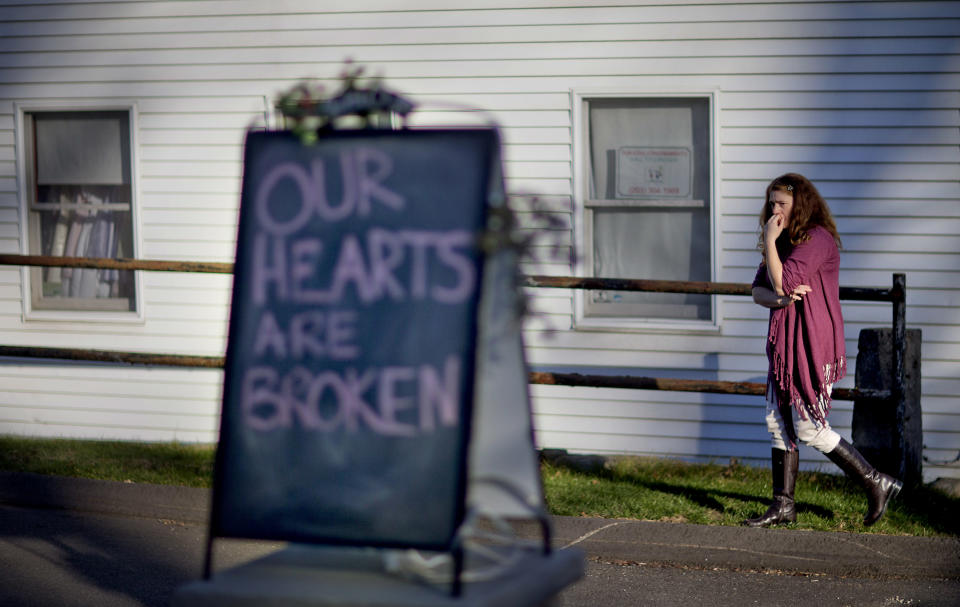 FILE - In this Dec. 15, 2012 file photo, shop owner Tamara Doherty paces outside her store just down the road from Sandy Hook Elementary School in Newtown, Conn. Although still relatively rare, there’s been no real reduction in the number of school shootings since security was beefed up around the country with measures such as safety drills and the hiring of police officers. (AP Photo/David Goldman, File)