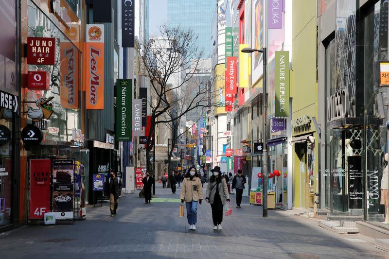 Women, wearing masks to prevent contracting coronavirus, walk in shopping district in Seoul