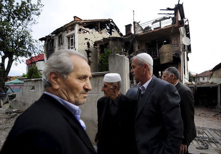 Neighbours talk in front of a damaged house in Kumanovo, Macedonia May 11, 2015. REUTERS/Ognen Teofilovski