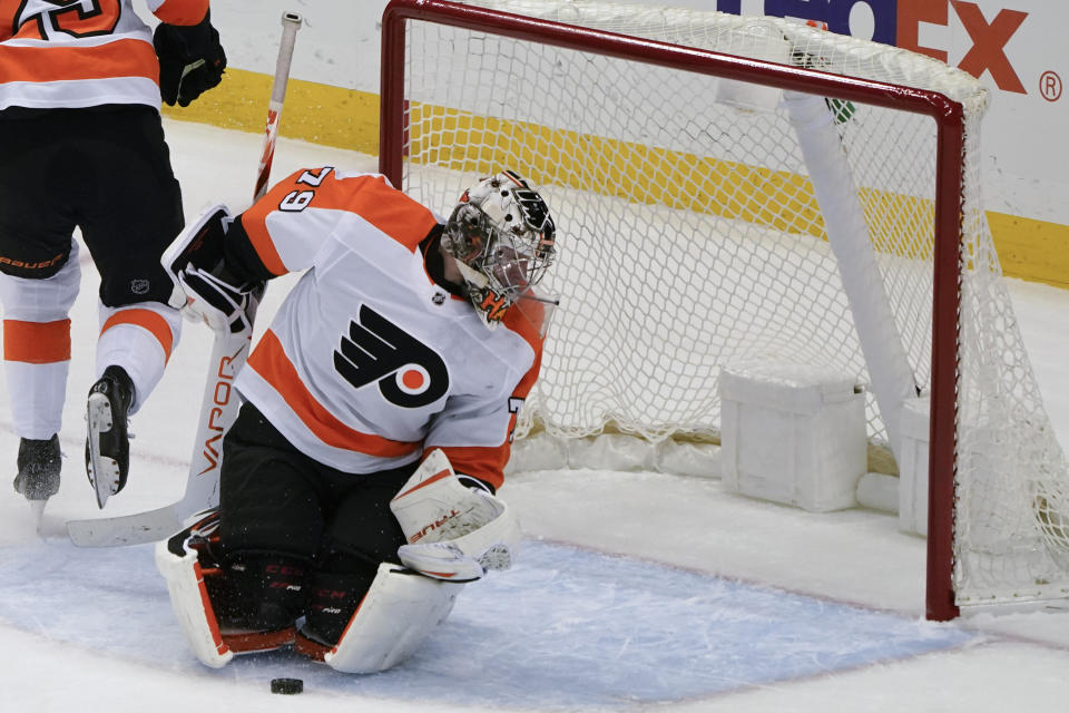 Philadelphia Flyers goaltender Carter Hart looks behind him as the puck is in front of him during the first period of an NHL hockey game against the Pittsburgh Penguins, Tuesday, March 2, 2021, in Pittsburgh. (AP Photo/Keith Srakocic)