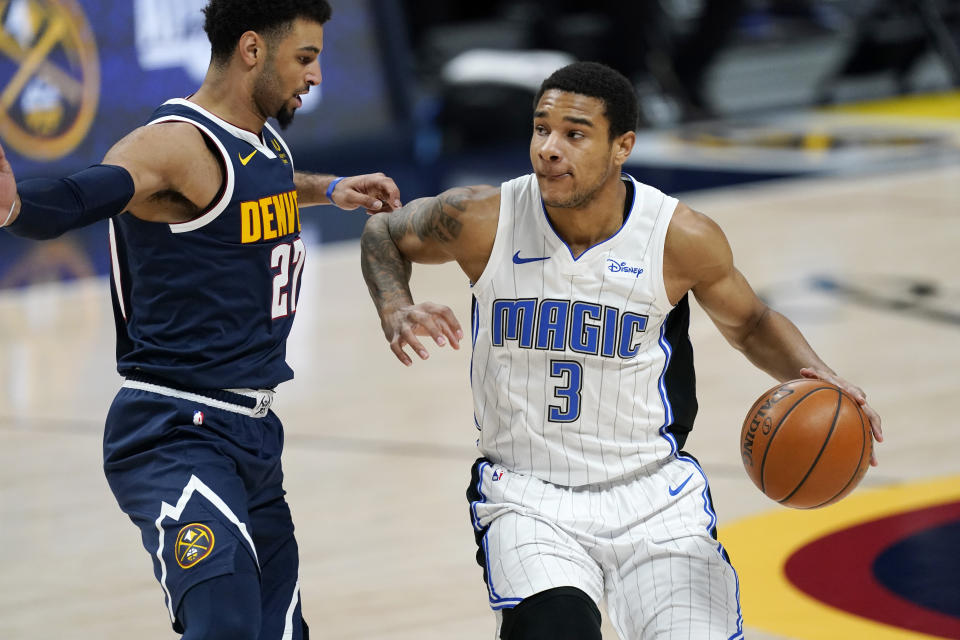 Orlando Magic forward Chuma Okeke, right, drives as Denver Nuggets guard Jamal Murray defends during the first half of an NBA basketball game Sunday, April 4, 2021, in Denver. (AP Photo/David Zalubowski)