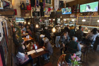 Customers eat and watch college women's lacrosse and beach volleyball matches on big-screen TVs at The Sports Bra sports bar on Wednesday, April 24, 2024, in Portland, Ore. (AP Photo/Jenny Kane)