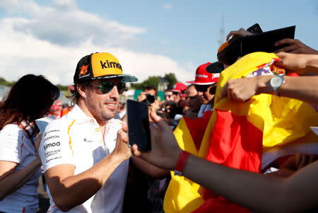 FILE PHOTO: Formula One F1 - Hungarian Grand Prix - Hungaroring, Budapest, Hungary - July 26, 2018 McLaren's Fernando Alonso signs his autograph for fans ahead of the Hungarian Grand Prix REUTERS/Bernadett Szabo