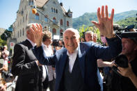 The former Fifa President, Joseph Blatter, center, surrounded by media representatives, waves to the press in front of the Swiss Federal Criminal Court in Bellinzona, Switzerland, at the last day of the trail, after the verdict has been announced, Friday, July 8, 2022. The trial ended with an acquittal. Blatter and Michel Platini, former president of the the European Football Association (Uefa), stood trial before the Federal Criminal Court over a suspicious two-million payment. The Federal Prosecutor's Office accused them of fraud. The defense spoke of a conspiracy. (Ti-Press/Alessandro Crinari/Keystone via AP)