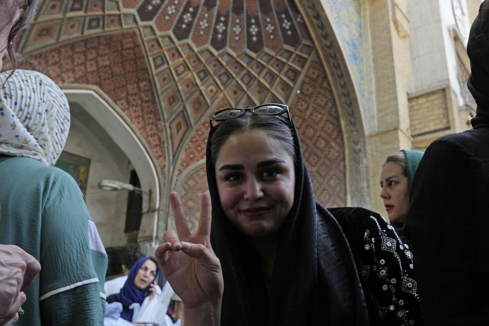 An Iranian woman flashes a victory sign as she walks at the old main bazaar of Tehran, Iran, Thursday, June 13, 2024. (AP Photo/Vahid Salemi)